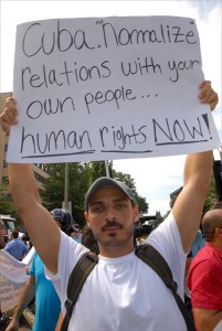 A young man across the street from the Cuban Embassy in Washington calls for “Human Rights Now!” on the island.