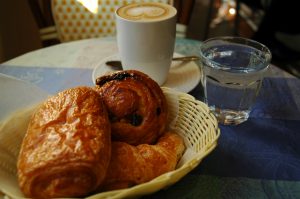 A basket of pastries and a caffe latte