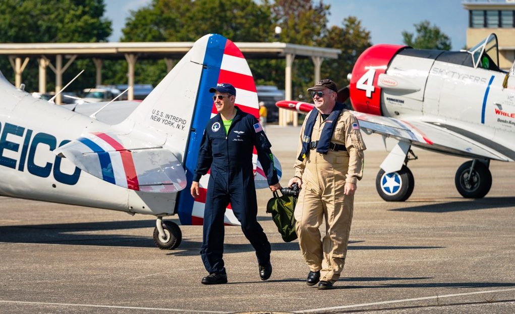 Pilot Mike Brockey and reporter Anthony C. Hayes walk the GEICO Skytypers flight line at Martin State Airport. The Skytypers are in Baltimore for Maryland Fleet Week. (Michael Jordan / BPE)