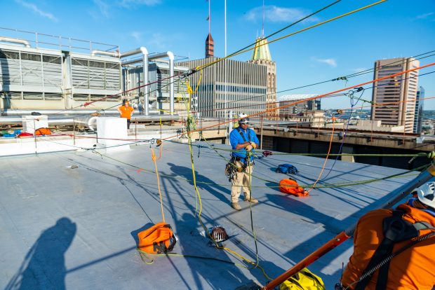 Baltimore, MD - Columbus Pollard of Over the Edge, a fundraising group specializing in high angle rigging, supervises as a participant depends the 25-story building at 100 N. Charles Street on Friday June 14, 2019.