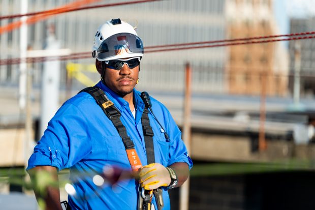 Baltimore, MD - Columbus Pollard from Over the Edge, a fundraising group specializing in high angle rigging, works on high angle rigging on top of 100 N. Charles Street Friday June 14, 2019.