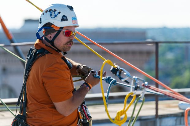Baltimore, MD - Todd Medeiros from Over the Edge, a fundraising group specializing in high angle rigging, works on high angle rigging on top of 100 N. Charles Street Friday June 14, 2019.