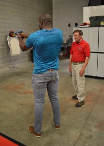 Concealed carry in Mayland: A student zeroes in on a target under the watchful eye of Dennis “Sarge” O’Toole. (Anthony C. Hayes)