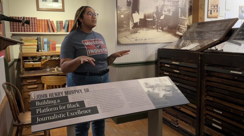 Alexis Ojeda-Brown leads the Forging Progress tour in the print gallery, highlighting the legacy of the AFRO media company. (courtesy BMI)