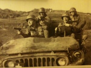 Brothers in Arms: Baltimore's Ace, Larry, and Rock Rosner: Ace Rosner (left front) holding his .45 pistol and his brother Larry’s (right front, behind the wheel) .45 as well. Taken at Anzio, Italy about two weeks before Ace lost his right arm. The two soldiers in the back seat were also from Baltimore. May 1944.