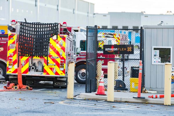 Extensive damage can be seen at the Amazon fulfillment center in Baltimore after sunrise Saturday morning. The damage is a result of a severe weather event late Friday night. Firefighters and special operations teams from Baltimore City Fire Department are seen working to locate and remove a second victim. (Mike Jordan/BPE Photo)