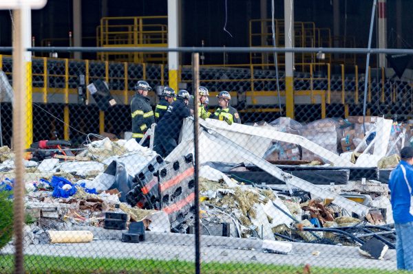 Extensive damage can be seen at the Amazon fulfillment center in Baltimore after sunrise Saturday morning. The damage is a result of a severe weather event late Friday night. Firefighters and special operations teams from Baltimore City Fire Department are seen working to locate and remove a second victim. (Mike Jordan/BPE Photo)