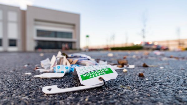 A first aid kit, believed to be from the heavily damaged Amazon fulfillment center, is seen strewn across the parking lot hundreds of feet away from the building. It appears the kit was not used, rather carried here by the severe weather. Extensive damage can be seen at the Amazon fulfillment center in Baltimore after sunrise Saturday morning. The damage is a result of a severe weather event late Friday night. Firefighters and special operations teams from Baltimore City Fire Department are seen working to locate and remove a second victim. (Mike Jordan/BPE Photo)