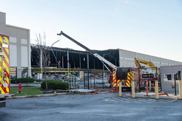 Extensive damage can be seen at the Amazon fulfillment center in Baltimore after sunrise Saturday morning. The damage is a result of a severe weather event late Friday night. Firefighters and special operations teams from Baltimore City Fire Department are seen working to locate and remove a second victim. (Mike Jordan/BPE Photo)