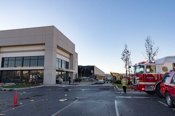 Extensive damage can be seen at the Amazon fulfillment center in Baltimore after sunrise Saturday morning. The damage is a result of a severe weather event late Friday night. Firefighters and special operations teams from Baltimore City Fire Department are seen working to locate and remove a second victim. (Mike Jordan/BPE Photo)