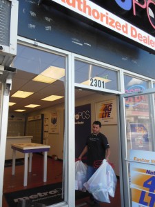 Hasim removes debris for his ransacked store. (Anthony C. Hayes)