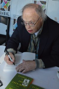 Robert Timberg signing a copy of his book Blue-Eyed Boy at the 2015 Baltimore Book Festival. (Anthony C. Hayes)