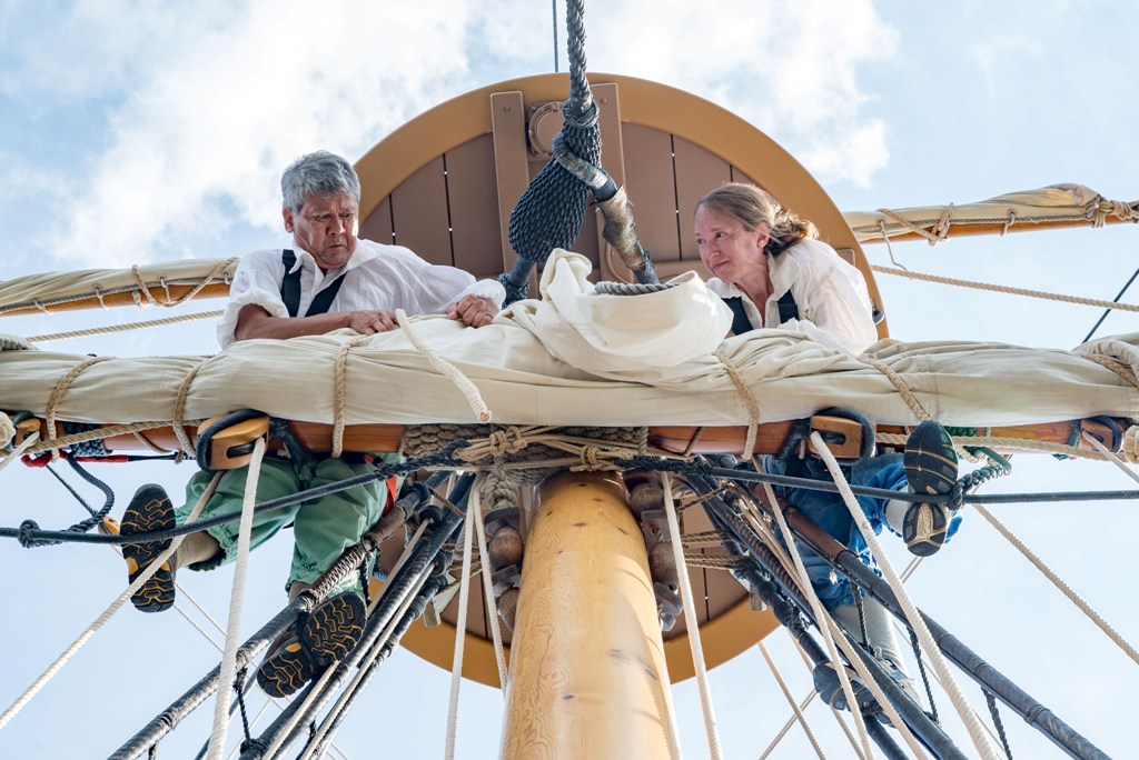 Crew members in early 17th century garb secure the main sail on the historic ship Godspeed. Godspeed is in Baltimore for the 2018 edition of Maryland Fleet Week. (Michael Jordan / BPE)