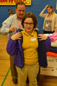 Operation Warm volunteer Mike Heiner of Horizon Services helps a student into her new winter coat. (Anthony C. Hayes)