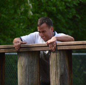 A Class of 2021 midshipman struggles to get over an obstacle at the 2018 US Naval Academy Sea Trials. Completing the Marine obstacle course is a prerequisite for all freshmen. (Anthony C. Hayes)