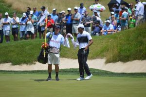 Caddie Joe LaCava hands Tiger Wods a towel at the 2018 Quicken Loans National in Potomac, MD. (Anthony C. Hayes)