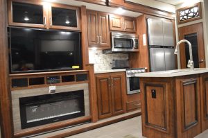 The interior of an RV at the 2018 Maryland RV Show. The well-appointed kitchen and den areas in a number of RVs included a TV, full-size refrigerator and gas fireplace. RVs such as this ranged in price from $150,000 - $200,000. (Anthony C. Hayes)