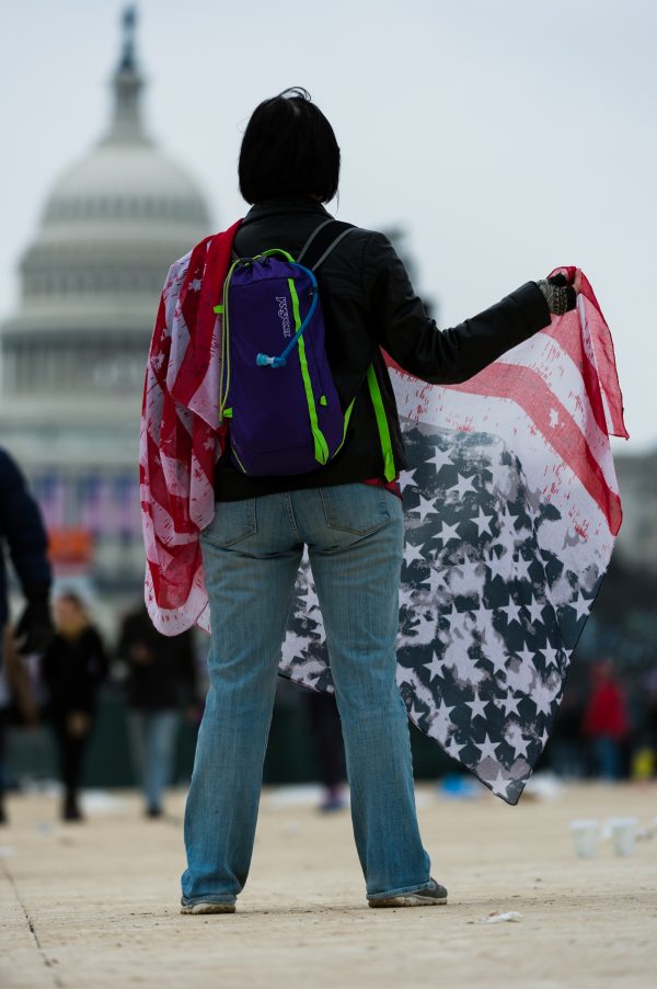 Inauguration Day: A woman who identified herself as "Morgan" is seen holding an American flag upside down in protest of President Trump. Morgan was seen on the National Mall moments after the Inaugural ceremony concluded. (Michael Jordan)