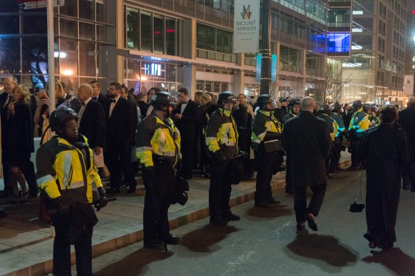 People dressed to the nines walk on their way to one of several Inaugural Balls. Amid heavily armed security and occasionally violent protestors, the scene had the duality of two worlds colliding. (Michael Jordan)