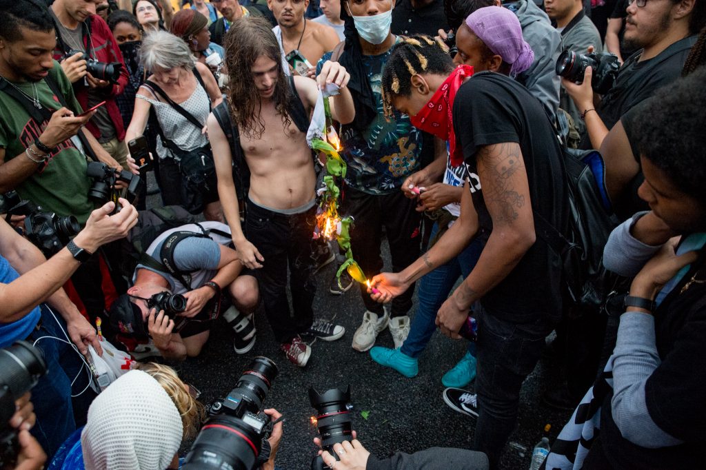 Washington DC, Aug. 12, 2012: Anti-Unite the Right 2 protesters ignite a flag at 15th St. and Pennsylvania Ave. (Mike Jordan/BPE)