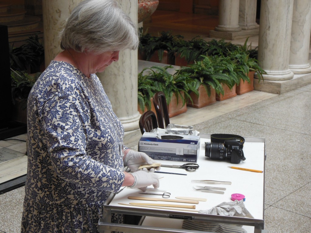 Volunteer Elissa O’Loughlin carefully opens a sealed artifact. (Anthony C. Hayes)